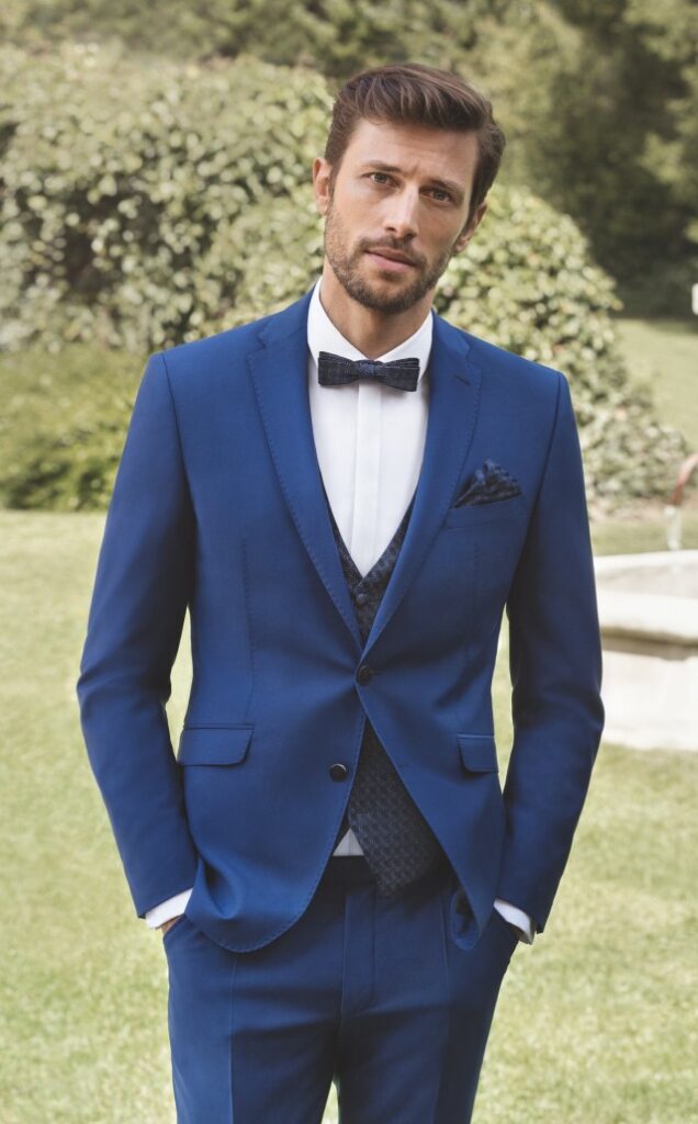 Bräutigam im blauen Hochzeitsanzug von Digel mit Weste und Fliege
